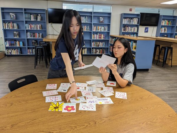 Sister Support co-presidents juniors Erin Park (left) and Hanna Park sort through on Wednesday, Feb. 21, in the Sunny Hills Lyceum paper decorated notes from club member to be donated to nursing and retirement homes.