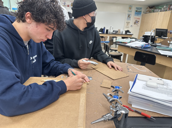 Juniors Lucas Saab (left) and Eunchong Lee cut out cardboard for their Advanced Placement Environmental Science class in Room 112 on Wednesday, Feb. 14. Students were doing this to examine with a microscope the cardboard and how it catches air particulates.