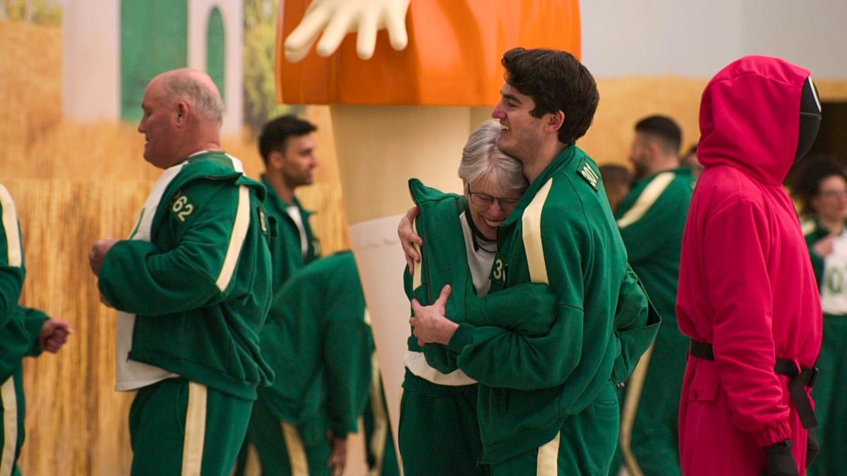 Leanne Wilcox Plutnicki (center) and her son Trey Plutnicki hug each other after both pass the finish line in a game called Red Light, Green Light in Episode 1 of “Squid Game: The Challenge” on Netflix. 