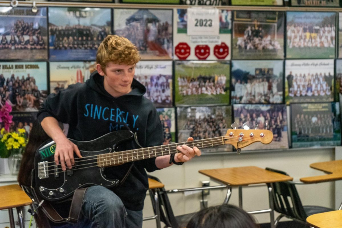 Sophomore Edward Galvez strums his electric guitar on Tuesday, Feb. 27, during lunch in Room 55, where he practices with his friends who play other instruments.