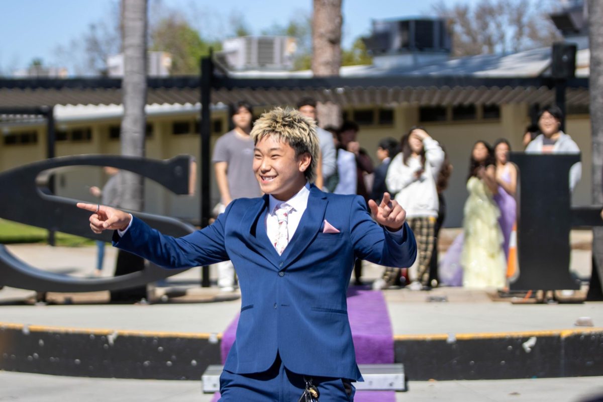 Junior Felipe Ko walks down the runway in a blue tuxedo during the Prom Fashion Show in the quad during break on Thursday, March 14. The Associated Student Body partnered with Friar Tux and Windsor to give students a taste of the outfits available for rental or purchase before the Saturday, April 6, prom, which will be held at the Aquarium of the Pacific.