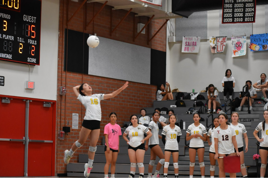Defensive specialist freshman Isabelle Kim serves the ball on Wednesday, Oct. 11, at the Troy High School gym in a match against Troy. Sunny Hills and Troy will not compete in the same league for the 2024-2025 season..
