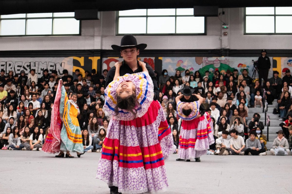 Latinx club members senior Ian Slobodien holds senior Katie Ortega by the waist as she leans back while grabbing onto his shoulders during their traditional folklórico performance.