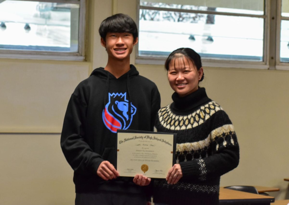 Junior Ethan Tam (left) and world language Chinese teacher Soon-Ya Gordon hold Gordon’s national Educator of Distinction award on Tuesday, Feb. 20, during lunch in her classroom, Room 36. The award is named after Claes Nobel, a grand nephew of Alfred Bernard Nobel — founder of the Nobel Peace Prize — and co-founder of the National Society of High School Scholars.