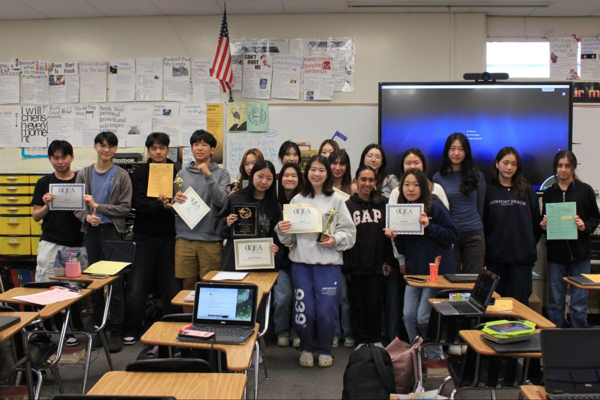 The Accolade staff members who competed in the Saturday, Feb. 24, Orange County Journalism Education Association’s annual write-off competition hold up their certificates, trophies and plaques during fourth period Monday, Feb. 26, in Room 138.