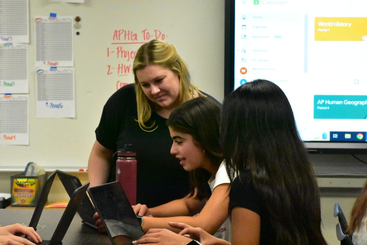 Social science teacher Kristin Kosareff checks on her students work in her fourth period Advanced Placement Human Geography class on Tuesday, May 14.