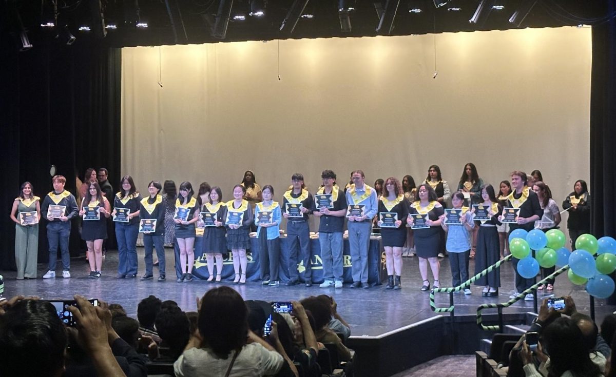 Seniors from the instrumental department eligible for the Conservatory of Fine Arts awards take a moment to celebrate with their certificates at the Laureate Ceremony in the Performing Arts Center [PAC] on Monday, May 13.