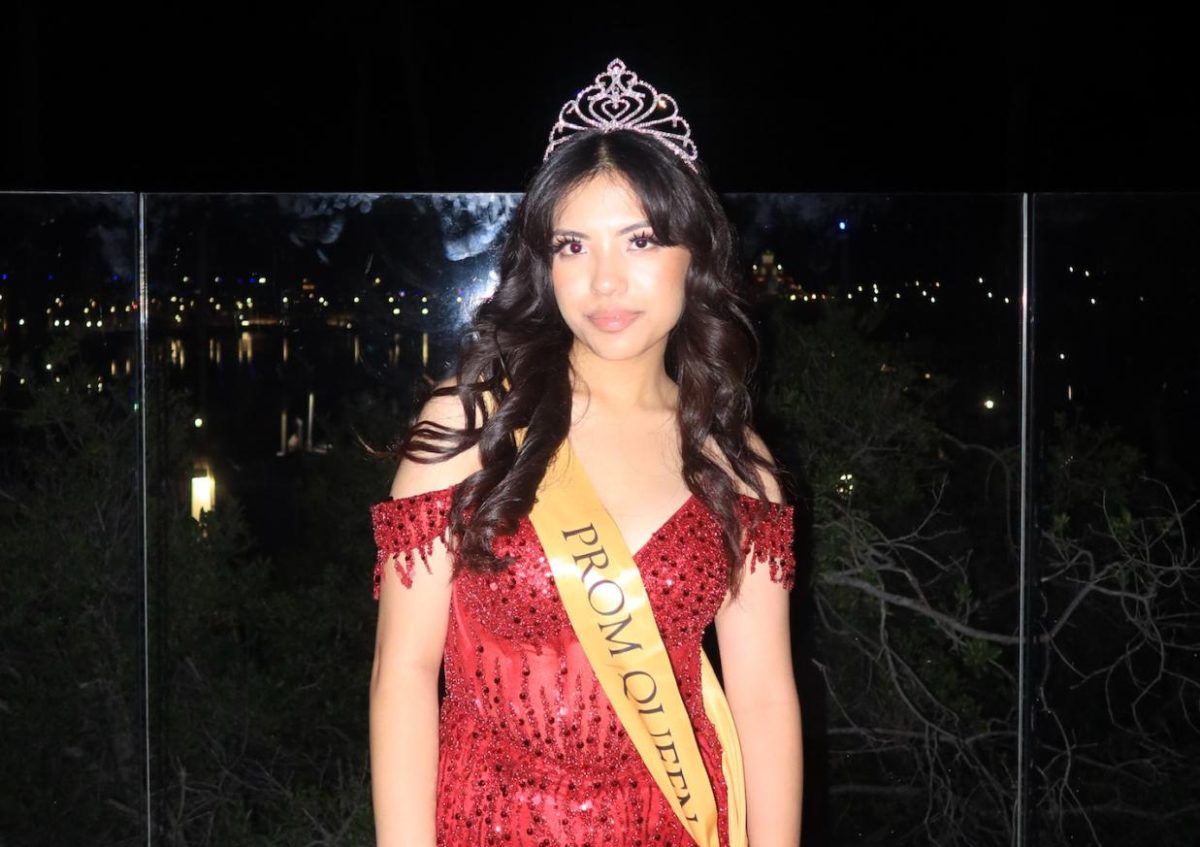 Senior Seannea Arceo poses with her tiara and a sash that reads “PROM QUEEN” at the end of the dance held on Saturday, April 6, at the Aquarium of the Pacific.