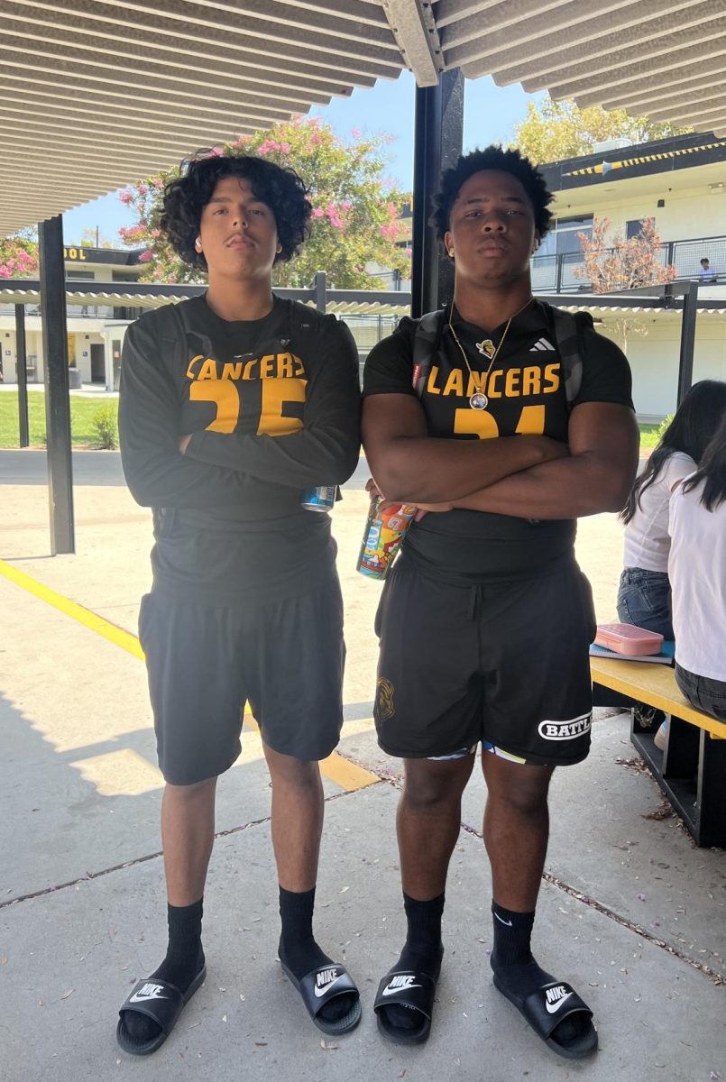 Football players senior Dorian Ramirez (left) and junior Austin Knight pose with their uniforms before the first football game against Troy on Friday, Aug. 23.