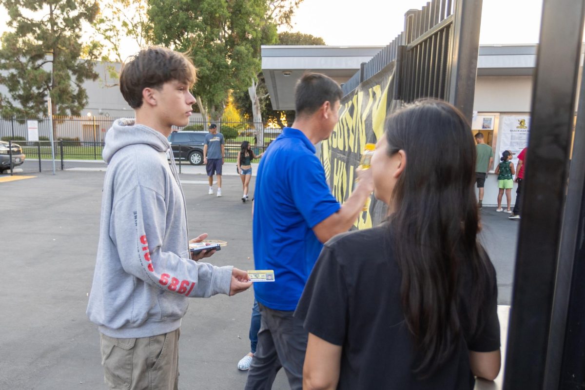 Senior Gunnar Okerlund uses his Associated Student Body Gold Card to get a free entrance to the Friday, Sept. 6, football game at the Buena Park High School stadium against the Woodrow Wilson Bruins.