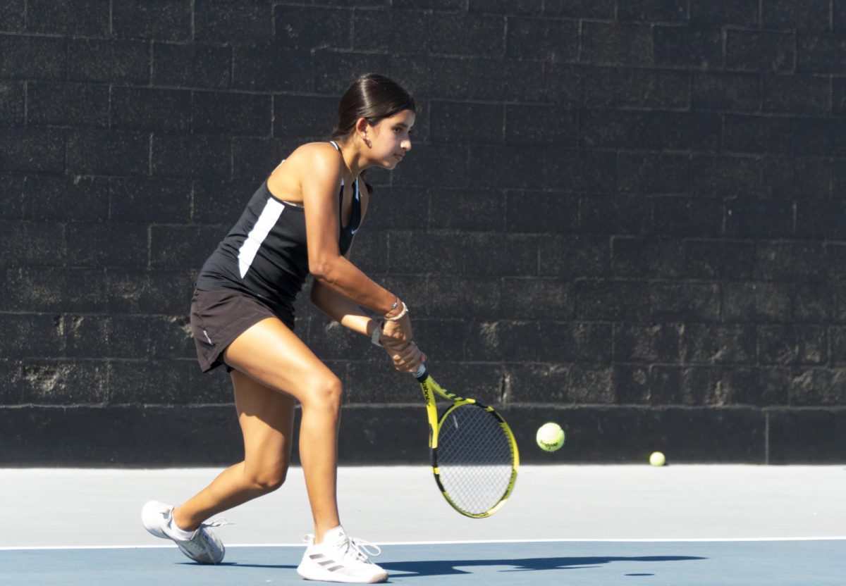 Singles No. 3 player freshman Vannia Pacheco swings her tennis racquet during practice on Tuesday, Sept. 10, after school.