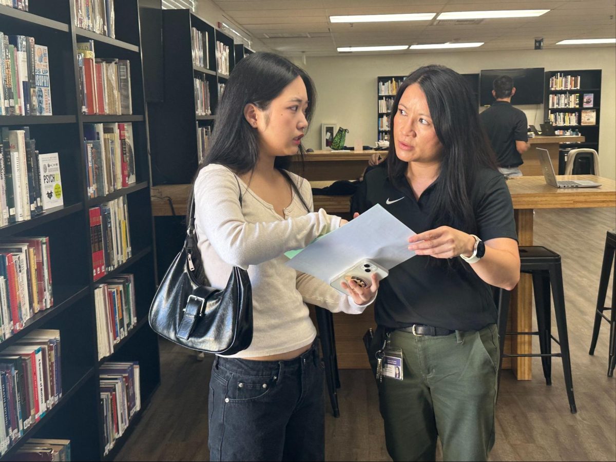 Assistant principal Betty Vutang (right) assists junior Jessica Choi with the student’s schedule-changing concerns in the Lyceum during the Tuesday, Aug. 6, Lancer Day registration.