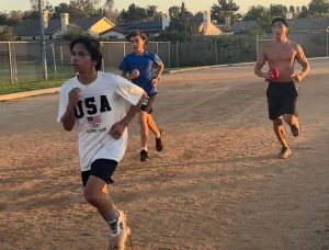 Freshmen Quirsten Barabag (front), freshman John Baker (middle) and junior Ryan Lim (back) run 300-meter repeats on Thursday, September 5, on the track as part of their twice-a-week speed work.