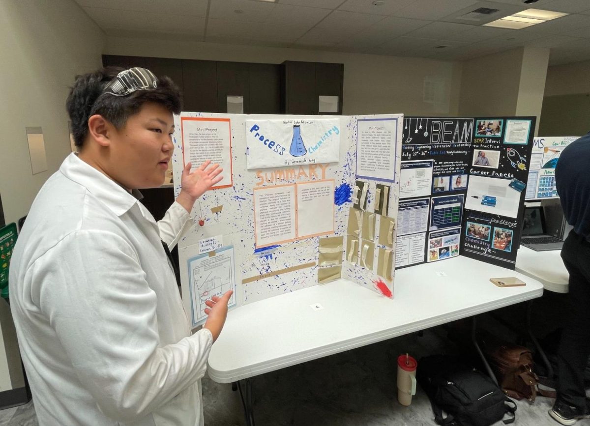 Senior Jeremiah Sung showcases his poster on the process chemistry of paint to Boeing employees on Wednesday, July 31, at the Huntington Beach Boeing Facility. Interns create posters based on the subject of their choice to showcase what they learned and researched.