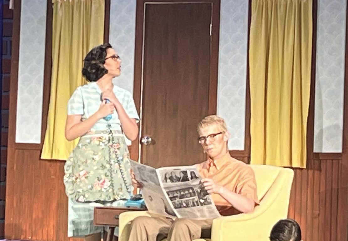 Senior Caleb Van Hook's character (center) sits on a chair while reading the newspaper in the comedy-thriller “Bye Bye Birdie” at Hope International University on Sunday, Nov. 10. Van Hook plans to continue to act on stage when he enrolls in college.