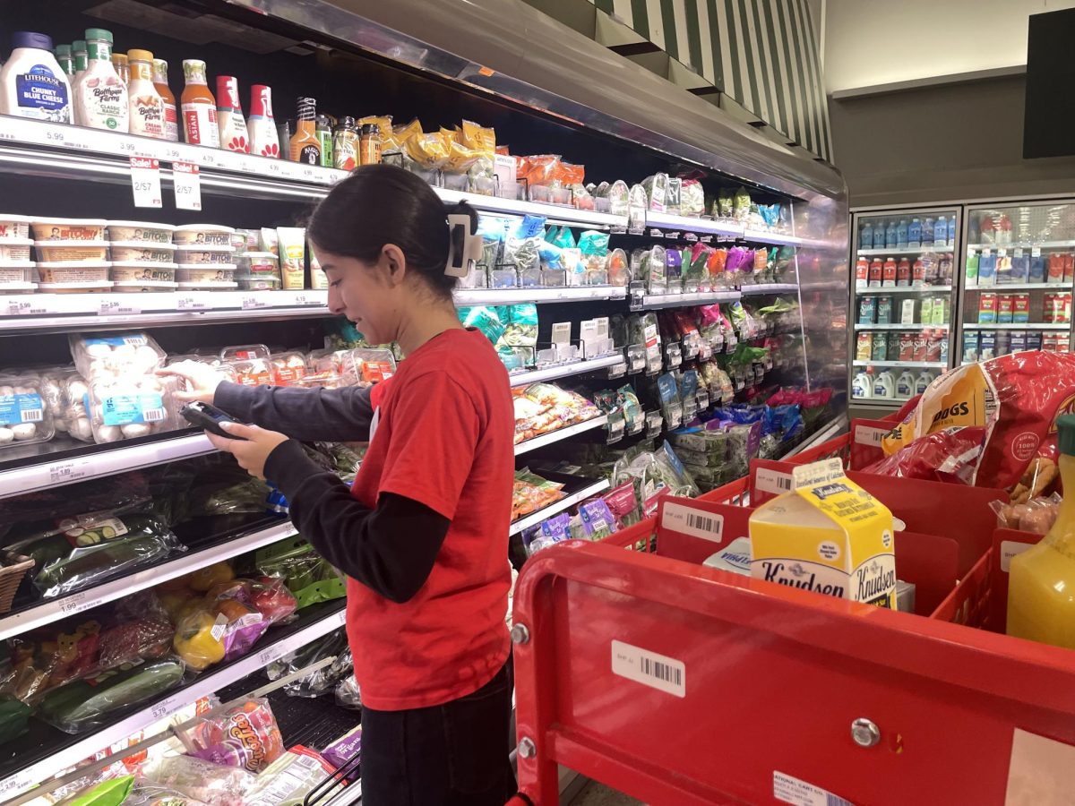 College student and Target seasonal worker Alyssa Vasquez identifies items that need to be restocked in the produce section of Fullerton Amerige Heights Town Center’s location.