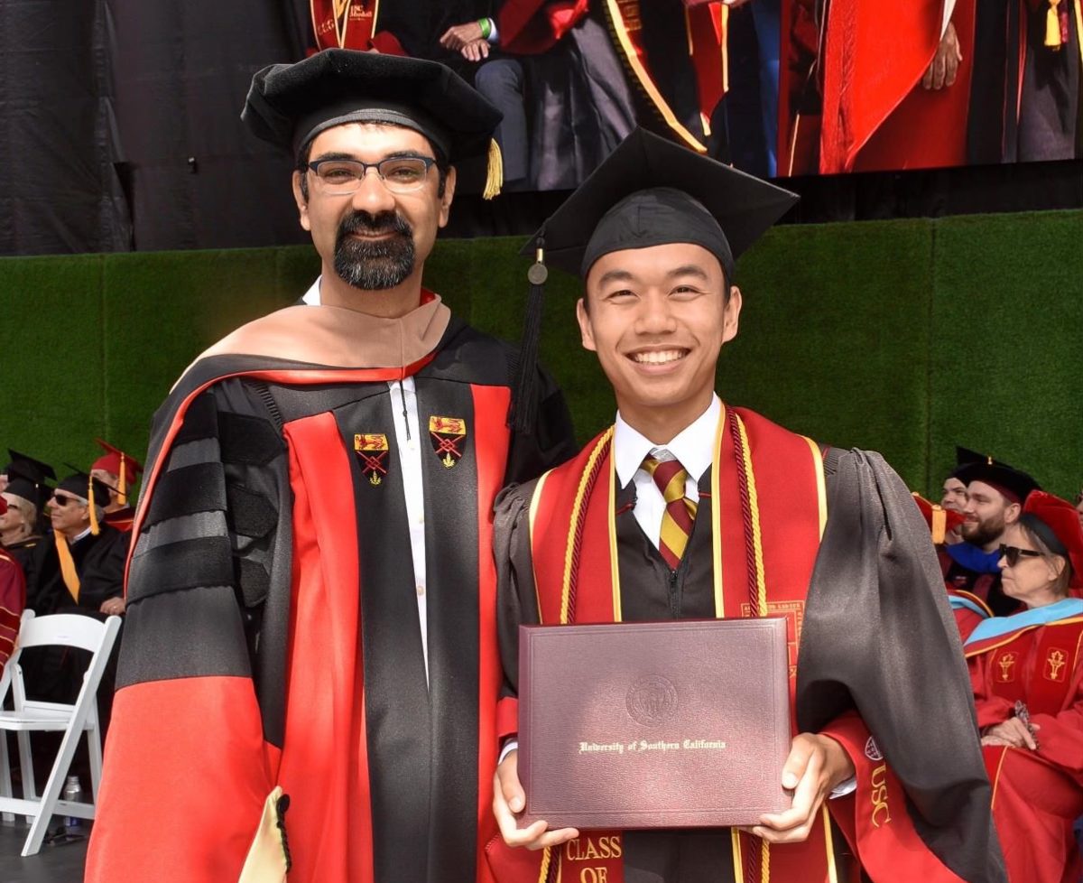 Andrew Ngo (right), who graduated from Sunny Hills in 2021, holds his bachelor’s degree in business administration during his commencement ceremony at USC on Friday, May 10. Ngo earned enough college credits from passing scores in his International Baccalaureate and Advanced Placement exams to help him graduate from USC in three instead of the traditional four years.