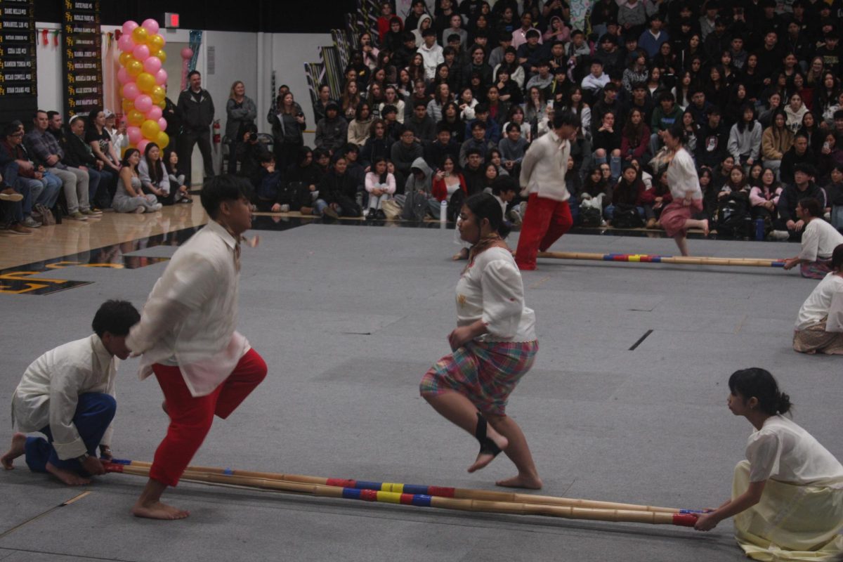 Juniors Connor Gabriel Fancuberta (left) and Madelyn Ann Ruedas perform the Filipino tinikling dance during the International Week assembly in the gym on Friday, Feb. 7.