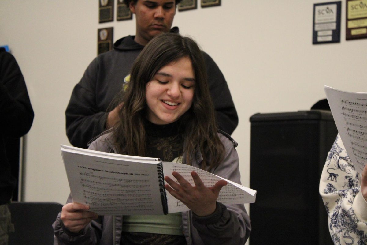 Senior Mahela Flores looks at a sheet music book as she practices “Benjamin Calypso” after school on Tuesday, Feb. 11, in Room 192.