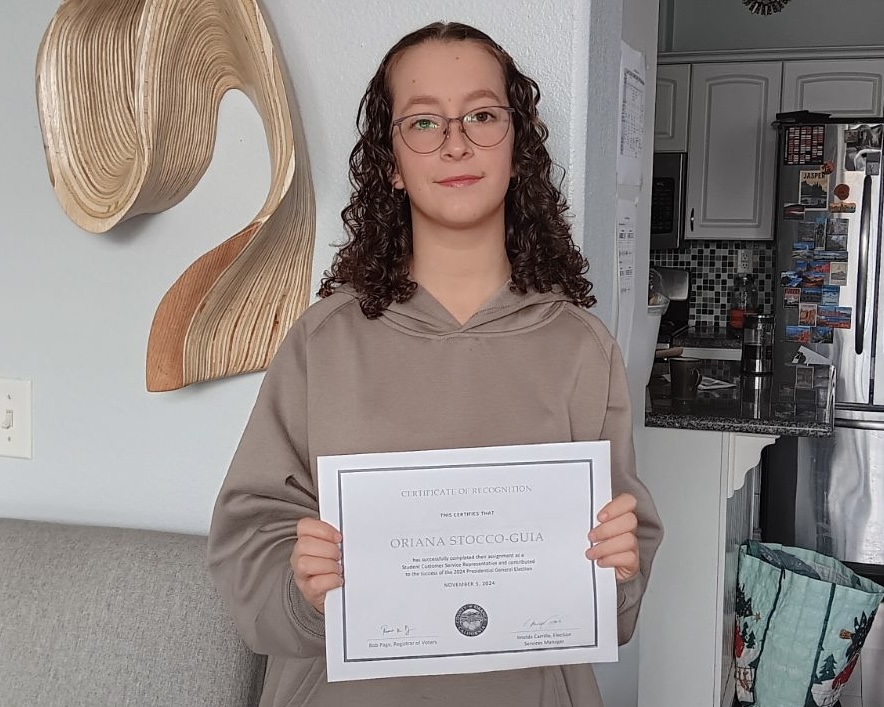 Junior Oriana Stocco-Guia holds up a Certificate of Recognition from the Orange County Registrar of Voters for her participation in the High School Student Volunteer Program on Tuesday, Nov. 5, for the presidential election.