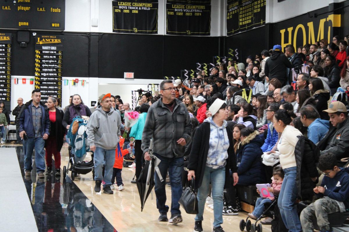 Parents and students sit on the gym bleachers as they wait for the cultural performances to begin on Thursday evening, Feb. 6. This was the first time the school offered an exclusive, evening-only performance for parents to pay $5 to come and watch the student cultural groups scheduled to showcase international traditions during the school day at the double second period assembly. In the past, parents could have come to watch the assembly for free.