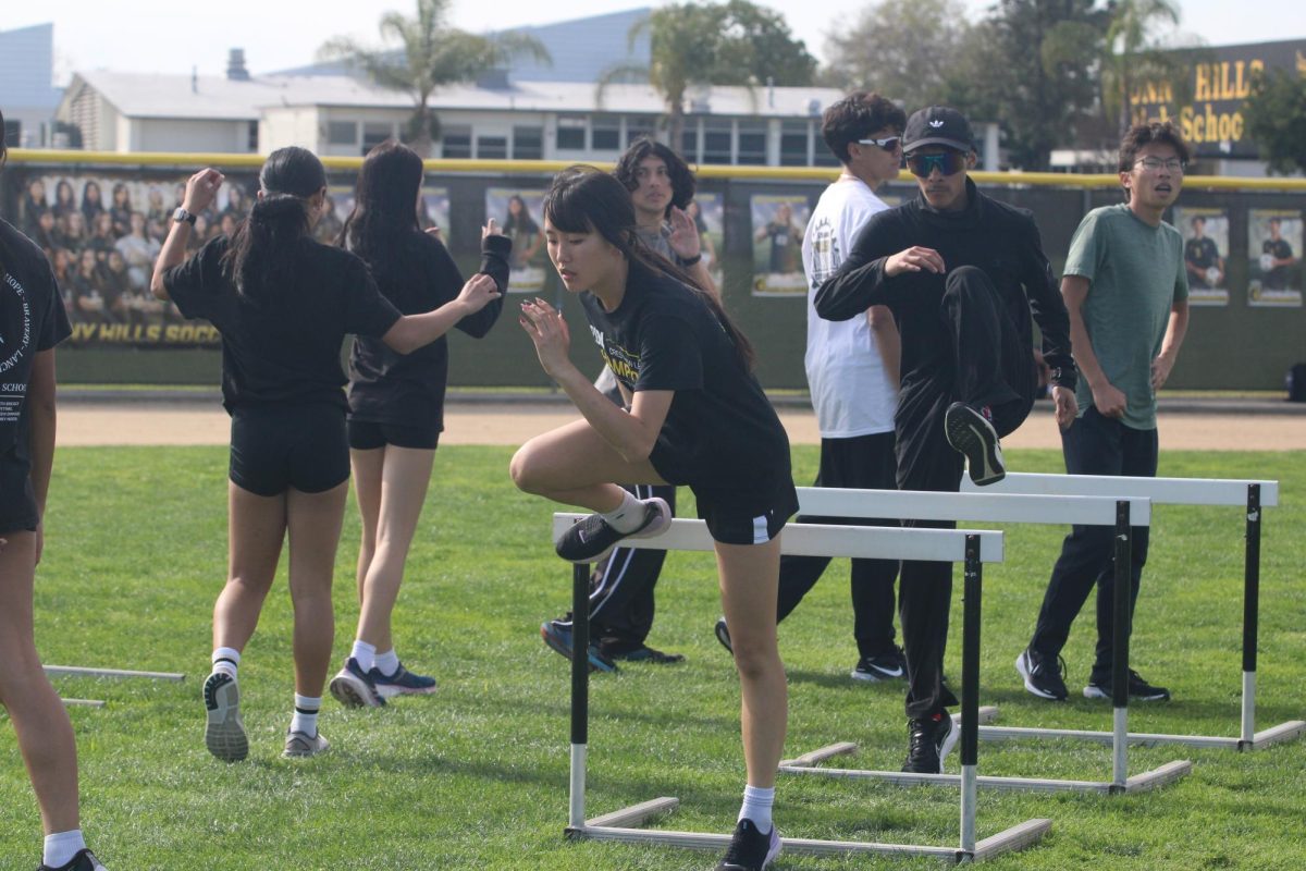 Sophomore Hannah Oh jumps over hurdles on the field Monday, March 10, during sixth-period practice.