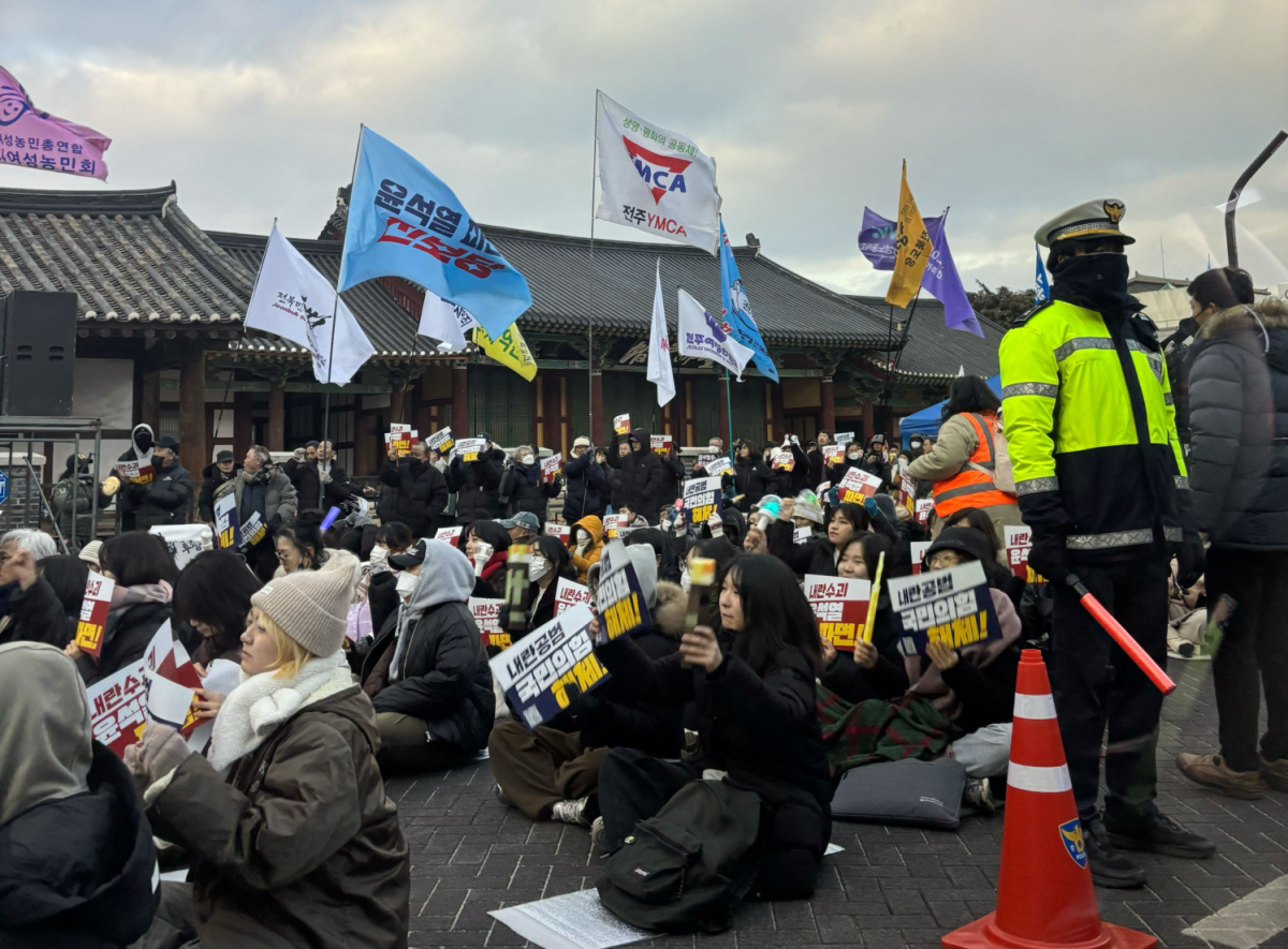 한국 시민들이 전주 거리에 앉아 윤석열 대통령에 반대하는 시위를 12월 27일 금요일에 벌이고 있다.