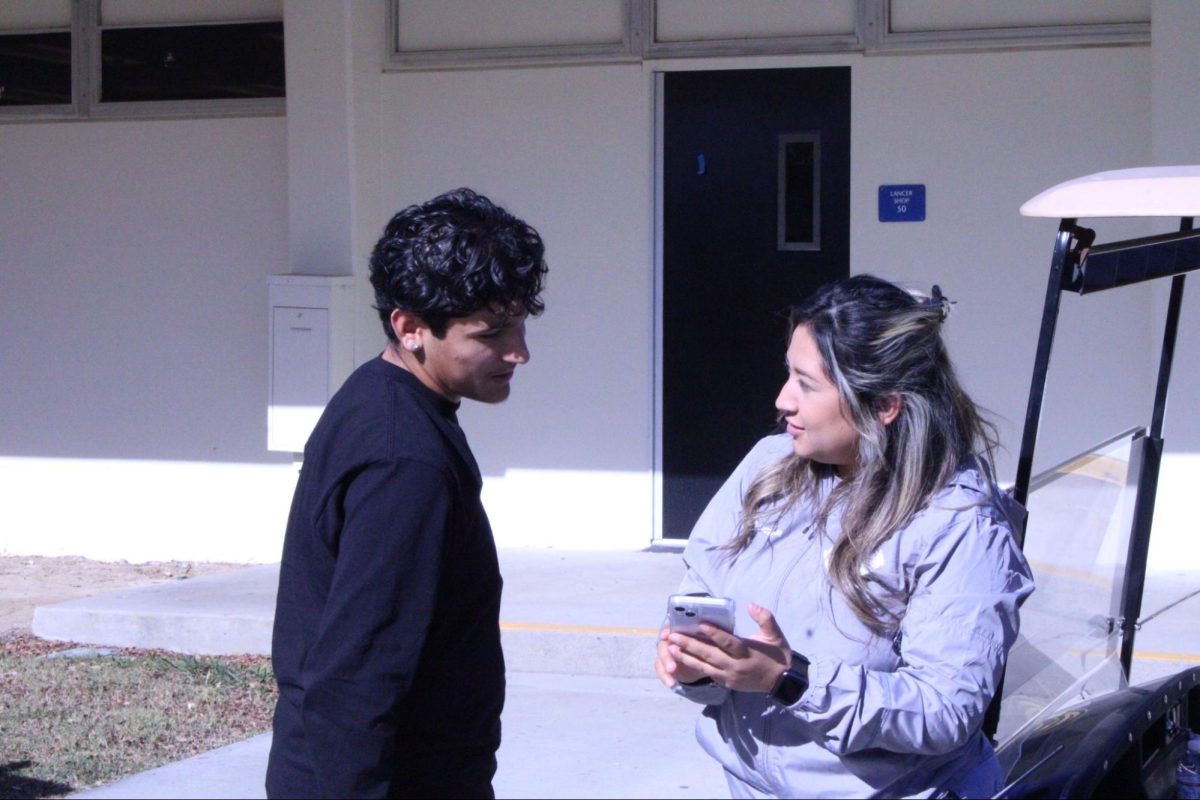 Campus supervisor Jennifer Davila (right) guides sophomore Andrew Loyola through the 5-Star app on Tuesday, Jan. 7, at the 30s wing. Loyola asked what would happen if the timer for the bathroom pass ran out.