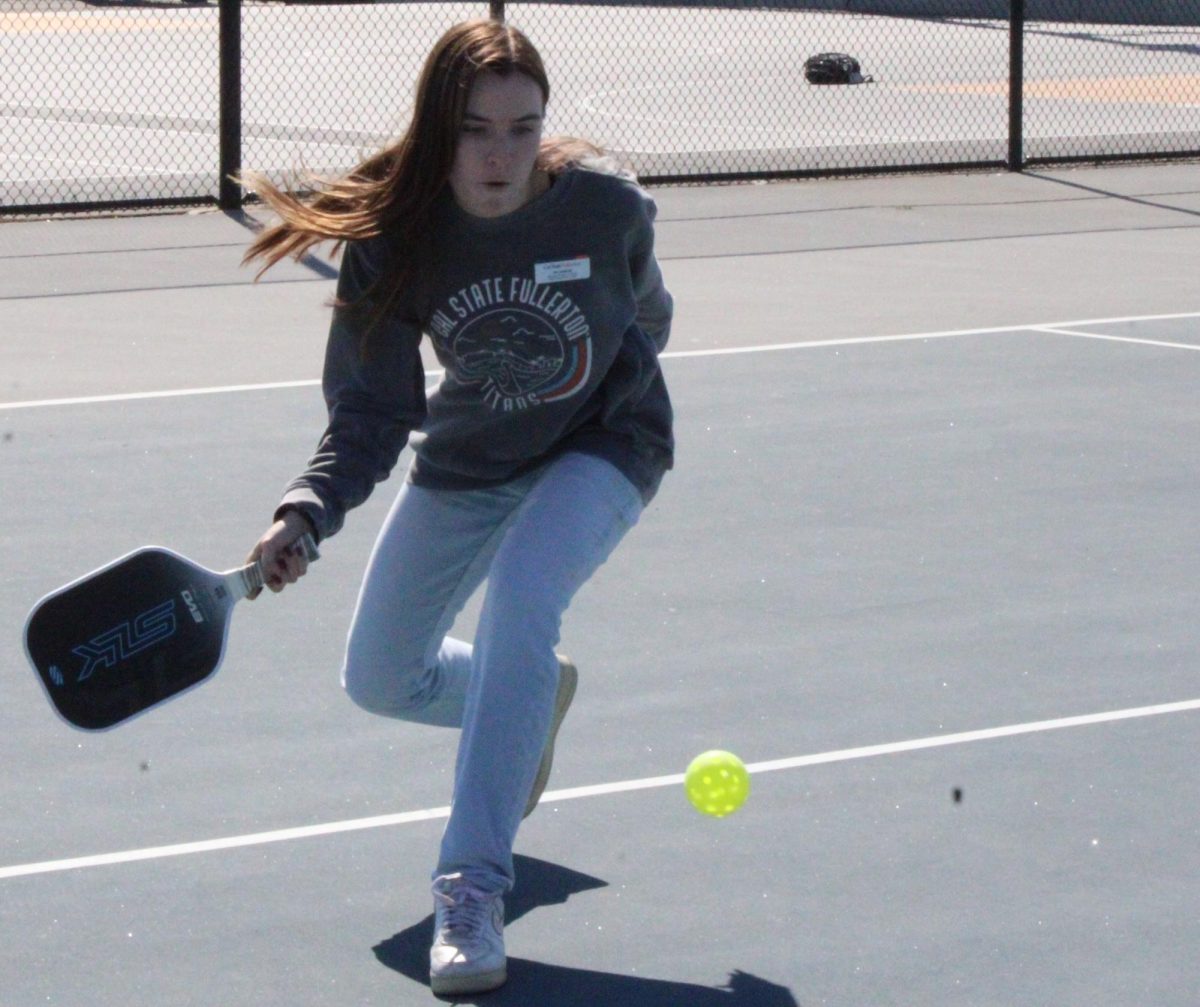 Jacquelyn Dunlap crouches down to hit the ball on Tuesday, Feb. 25, on the tennis courts.