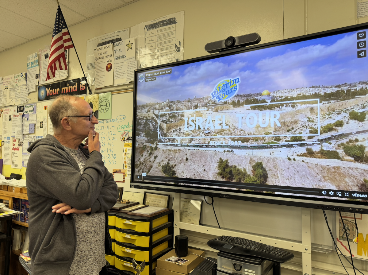 Class of 1974 alumnus and former Spanish teacher Gene Bordy looks Wednesday, April 23, in Room 138 at the Pilgrim Tours website featuring his dream trip to the Holy Land of Israel. Bordy has been unable to go on his scheduled tour the past two years because of the Israeli-Hamas conflict as well as several airlines’ decision to no longer offer flights to that part of the Middle East.