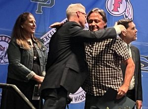 Social science teacher Jeff Gordon (right) shares a congratulatory hug from assistant superintendent Karl Zener during the Monday, May 12, celebration of retiring teachers in the Performing Arts Center. The Fullerton Joint Union High School District organized the event to give its 43 certificated retirees a commemorative plaque recognizing the number of years they've contributed to their students. 