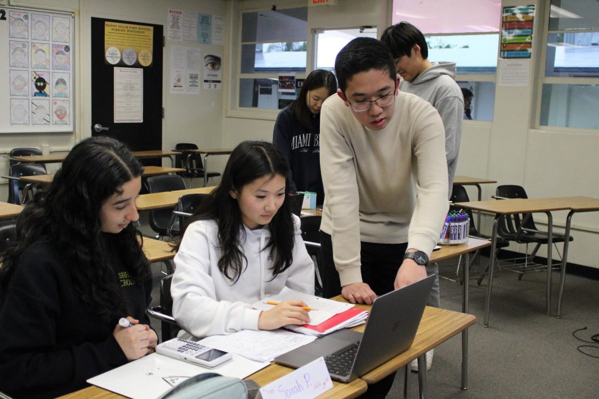 Senior Ethan Hsu (right) points at the laptop screen of junior Julia Kim (center) in his attempt to tutor her after school at the Algebra Center on Thursday, March 6, in Room 45. Also helping Kim is senior Sarah Patino.