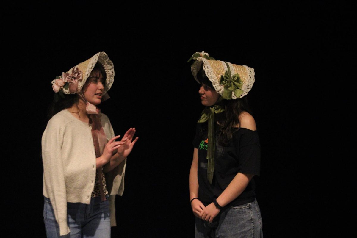 Abigail Veyna (left), who plays Charlotte Lucas — a friend of the female lead —  talks to senior Kathleen Handley, who plays one of the main characters, Elizabeth Bennet, during their fourth-period rehearsal of the stage version of Jane Austen’s classic novel, Pride and Prejudice on Friday, April 25, in the Performing Arts Center [PAC]. The two-hour-and-15-minute play consisting solely of theater students will debut tonight at 7 in the PAC.