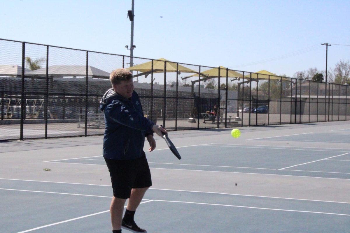 Jordan Brinkley swings his paddle to hit the pickleball on Tuesday, Feb. 25, on the tennis courts. 