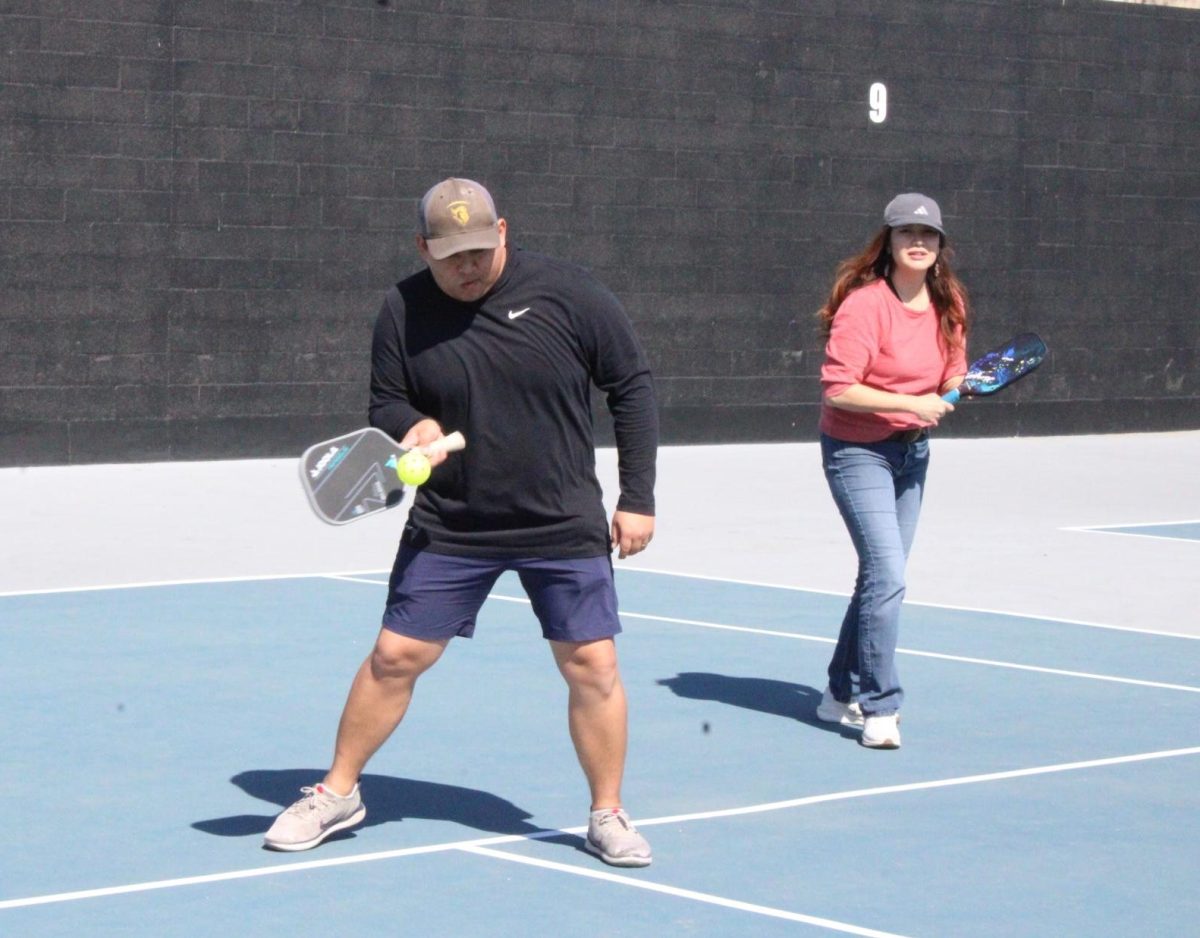 Andrew Guevara (left), playing with Kellie Ma, swings his paddle to hit the pickleball on Tuesday, Feb. 25, on the tennis courts.