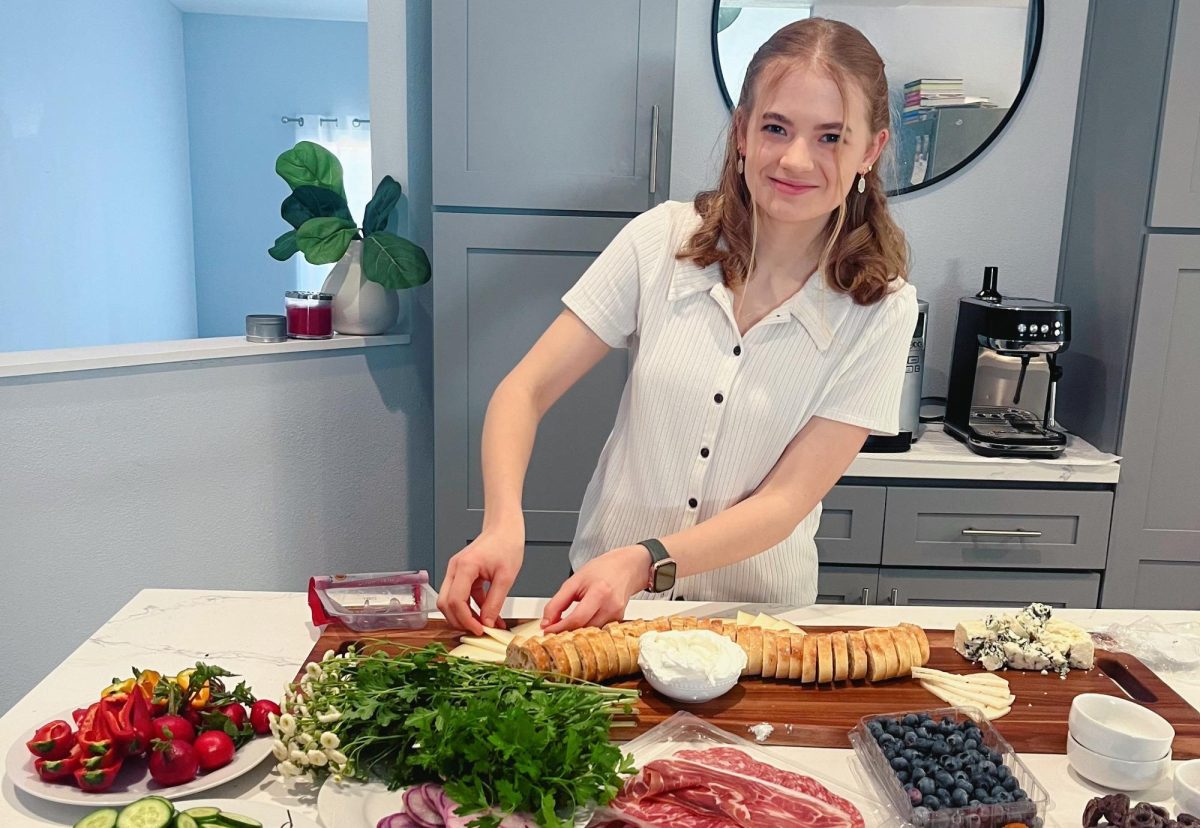Senior Sophia Kiker crafts a spring- themed charcuterie board for a pre-prom party order on April 23, 2024, for her business.