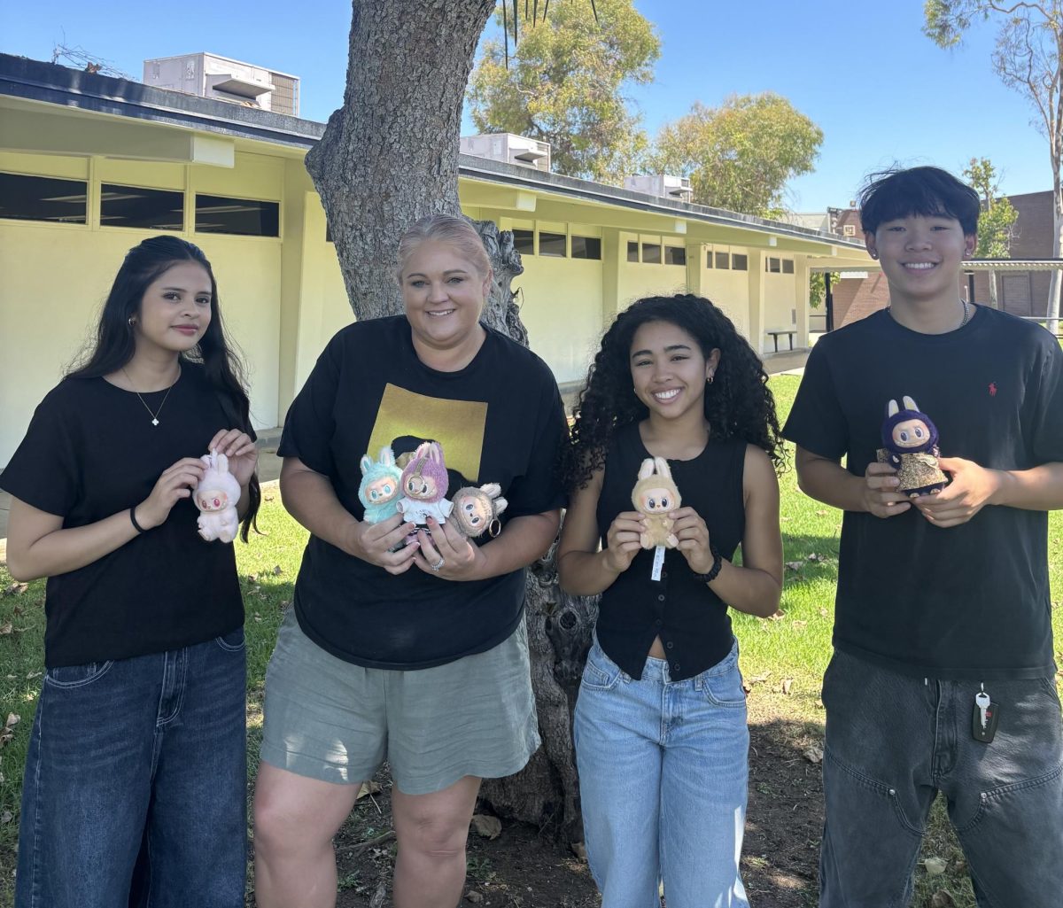 Senior Welcy Calderon (left), 3D design teacher Chablis Bates senior Ashley Cal and junior Evan Lee hold their Labubus on Friday, Sept. 5.