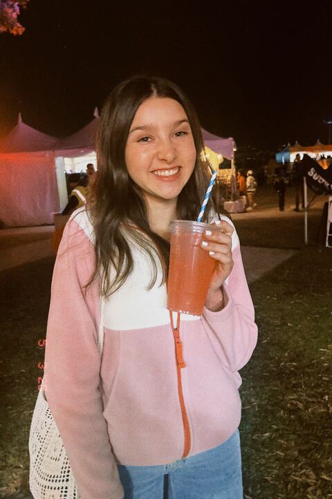 Junior Cambria Dominguez smiles and holds a drink at the BeachLife music festival. 