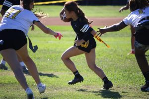 Senior rusher Sydney Kim runs with the ball in her hand to pass the opposing team’s attempt at removing her flag during the game against Whitney High School on Monday, Sept. 8.