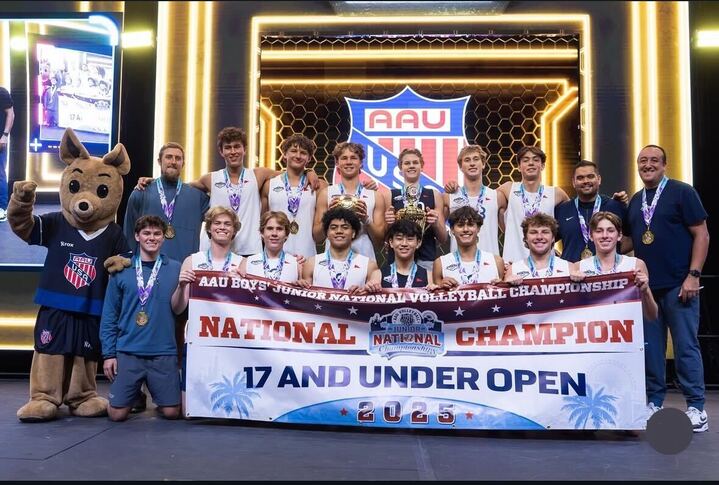 Senior Jake Sueki and his club volleyball team carry their National Champion title banner.  
