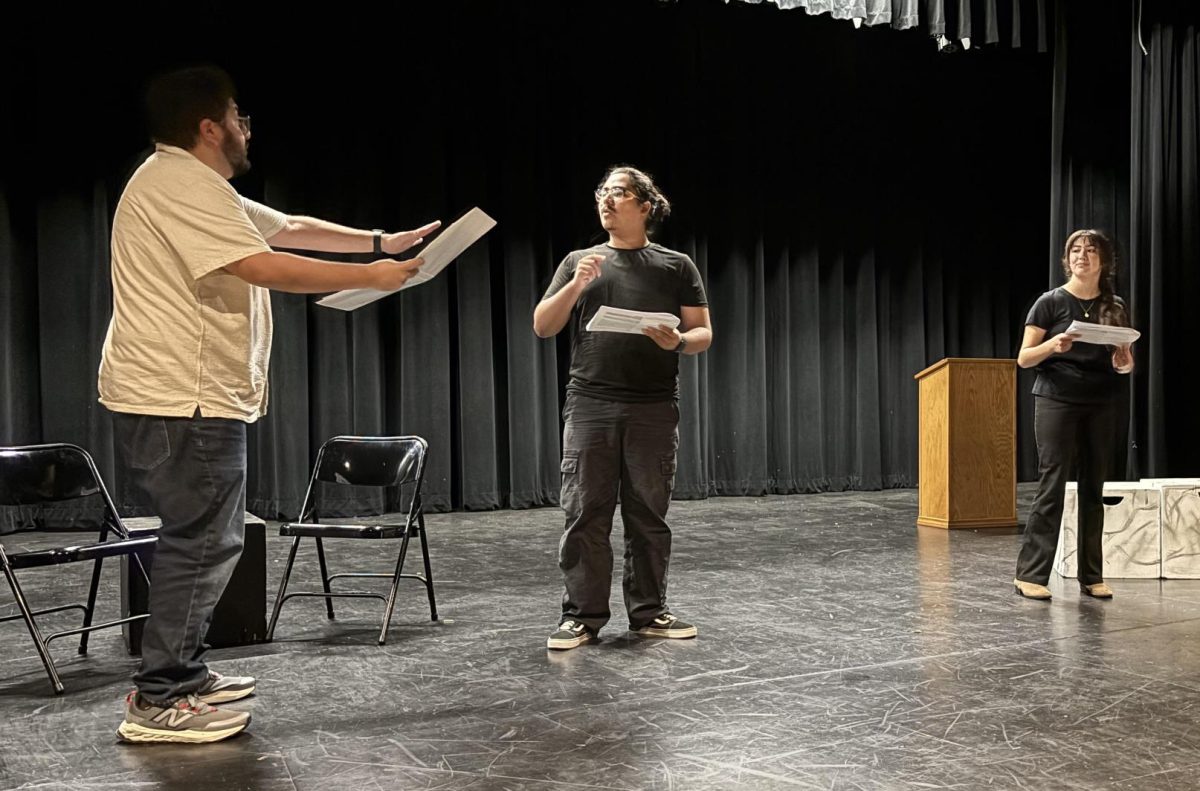 Guest director Alfonso Neavez (left) shows Michael Olivares (middle), who plays the main character in “The Importance of Being Earnest,” his vision for how a scene should be executed in the Performing Arts Center on Thursday, Aug. 25.