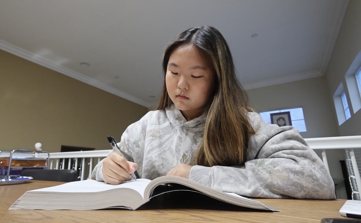 Senior Nicole Park writes in her Advanced Placement Chemistry preparatory book on Friday, Oct. 3. She used this resource to study for her exam last year.