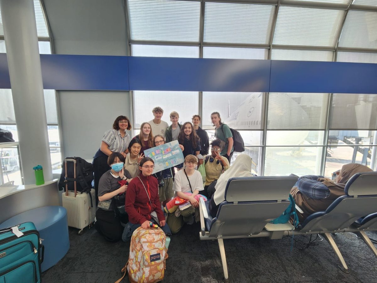 Senior Thomas Oltman (top left) stands with fellow exchange students and the group leader next to their plane from Chicago to Frankfurt on June 10.