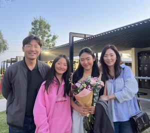 Sophomore Kaylynn Park (second from the right) smiles for a family photo in front of the PAC after her dance showcase on Saturday, April 12. 
