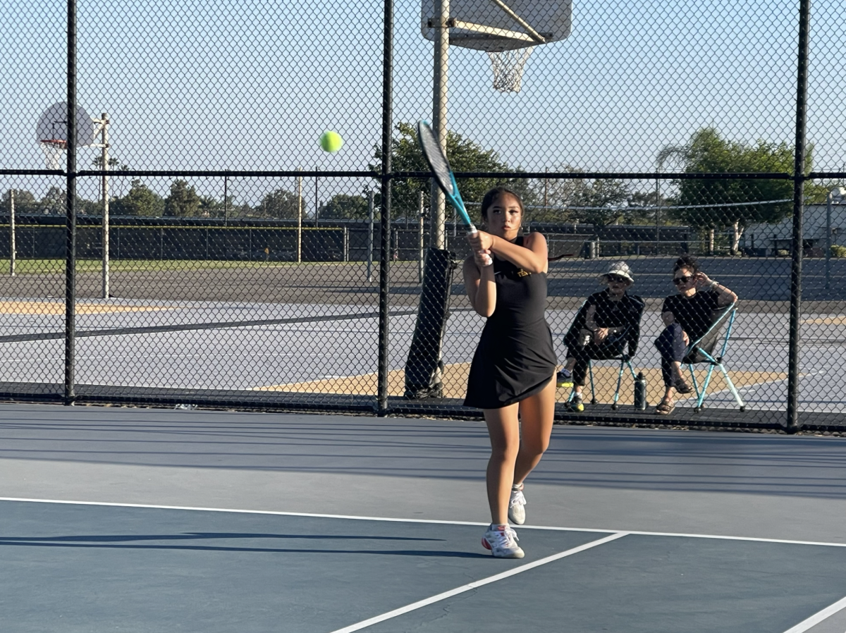 Junior Julianne Brie Tubiera swings to hit the ball during a home match against Crean Lutheran High School after school on Tuesday, Oct. 7 at the tennis courts. The final score was 4-14.