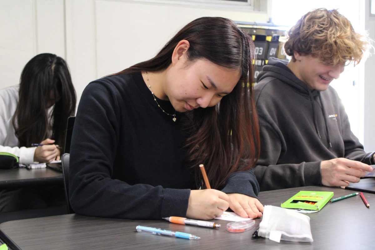 Senior Francess Pak draws a portrait of her secret santa for her Advanced Placement Literature class during the third period on Thursday, Dec. 4, in Room 14. 