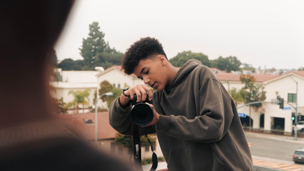 Junior Elias Anizor adjusts his camera as he takes photos for his passion project, an editorial shoot celebrating the one-year anniversary of when he embarked on his photography business at Fullerton College on Saturday, Oct. 25.