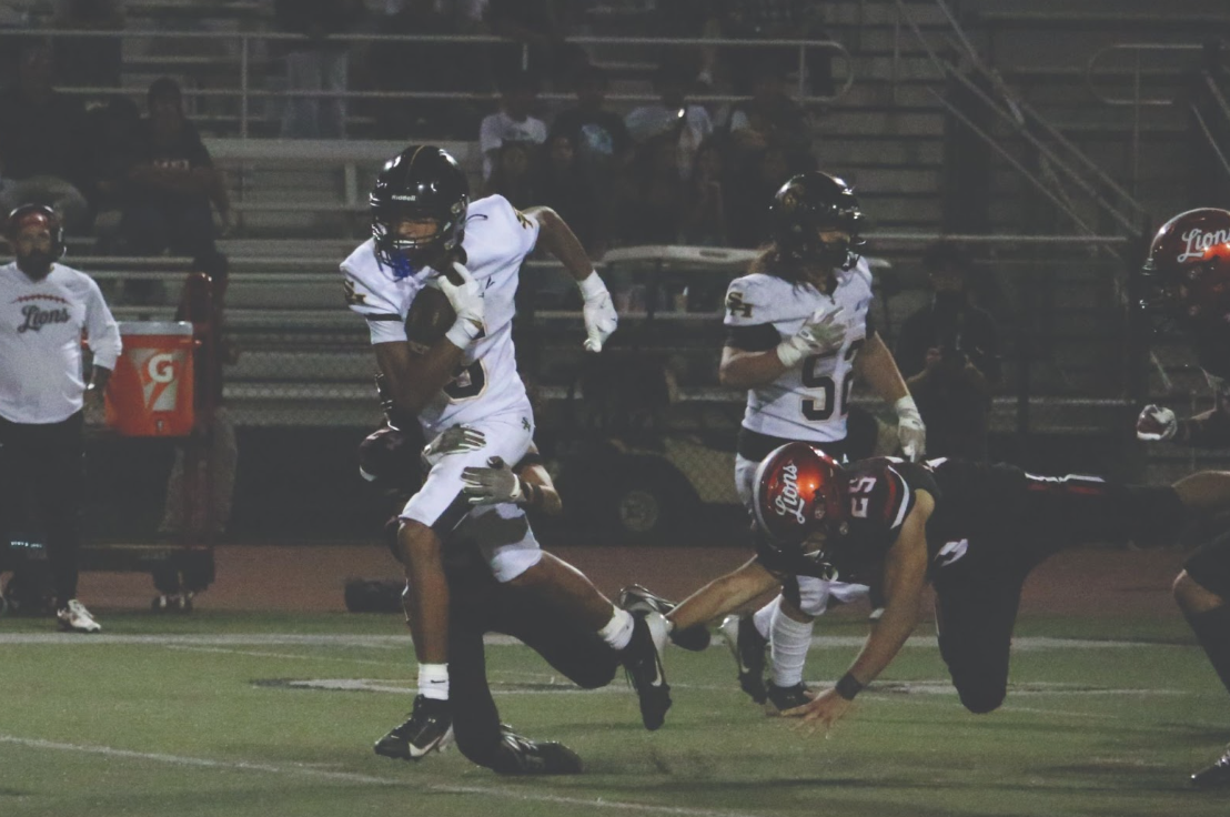Wide receiver senior Kruz Sandle runs across the field to score the first down and lead the team to victory on Friday, Aug. 22 at Westminster High School.