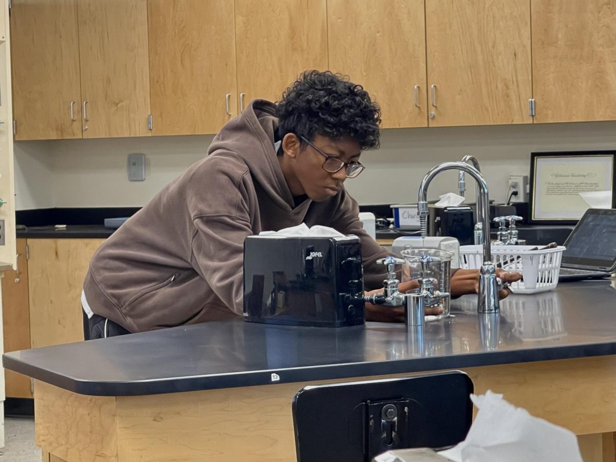 Sophomore Hin Agendia fills a beaker with water for a Chemistry Honors lab regarding the relationship between volume and temperature in Room 115 during the second period on Friday, Jan. 9. 