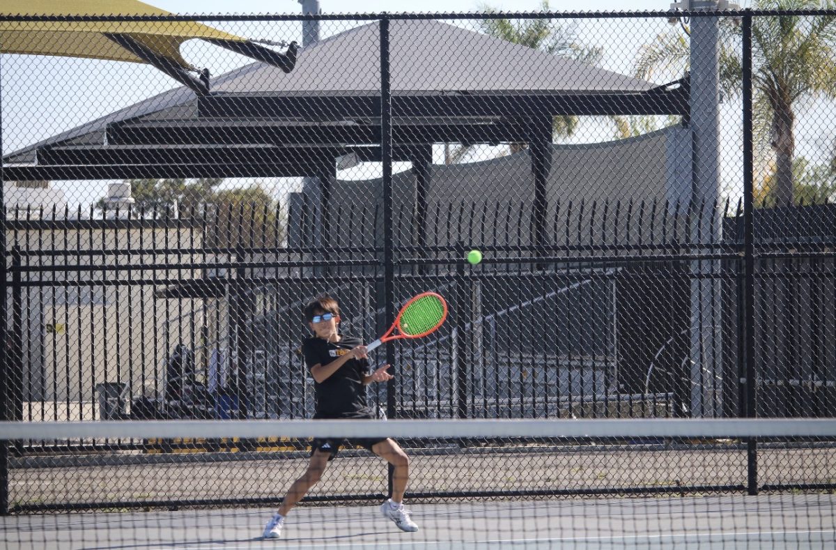 Singles player freshman Troy Yoo prepares to hit the ball back to his opponent from Orange Lutheran High School during a singles match on Tuesday, March 10, where Orange Lutheran won 10-8.